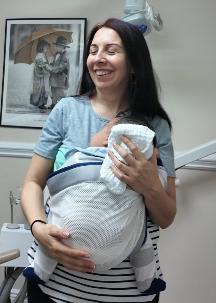 Mother smiling during tongue-tie recovery aftercare with baby